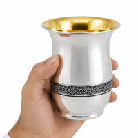 A hand holding a handmade Kiddush cup decorated with filigree, 925 sterling silver