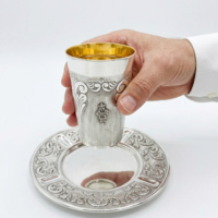 A hand holding a quality Kiddush set, decorated by hand in pure 925 silver