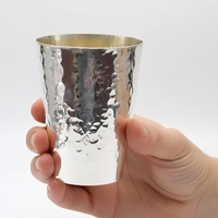 Hand holding a handmade Kiddush cup, hammered from pure 925 silver, made in Israel