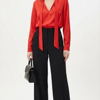 חולצת סאטן אדומה עם עניבת צוואר ומכנסיים שחורים מחויטים – מראה עוצמתי ואלגנטי