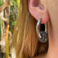 Silver hoop earrings with a green stone bead