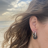 Silver hoop earrings with a green stone bead