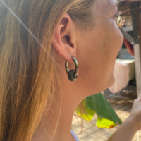 Silver hoop earrings with a green stone bead