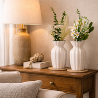 עציצים קרמיים עם פרחים מלאכותיים לבית