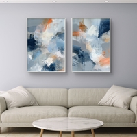סט תמונות קנבס זוגי בגווני כחול, אפור וכתום בעיצוב אבסטרקטי רך – תכשיט לבית