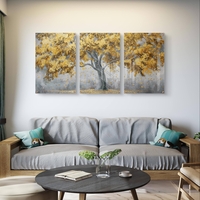 תמונת זכוכית שלישייה עם עץ זהוב ועלים מרחפים על רקע אפור בעיצוב מודרני