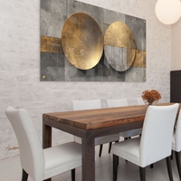 תמונת זכוכית לרוחב עם שני עיגולים מוזהבים מעל רקע אפור גאומטרי – תכשיט לבית