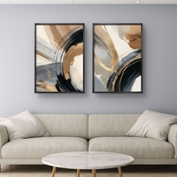 זוג תמונות קנבס מופשטות בגווני שחור, זהב וחום בהיר עם משיחות צבע רחבות בעיצוב מודרני