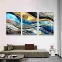 תמונת זכוכית מחולקת לשלושה חלקים בגווני טורקיז, שחור וזהב בעיצוב אבסטרקטי מודרני תלויה מעל שולחן אוכל לבן.