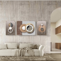 סט תמונות זכוכית מחולקות בעיצוב גאומטרי מודרני עם מעגלים, קווים וגווני זהב, עץ ואפור בסלון מעוצב