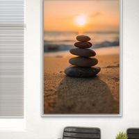 תמונת קנבס של ערימת אבנים על חוף ים בשקיעה רכה – קולקציית NEXTGEN BY BAR