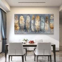 תמונת זכוכית לרוחב עם נוצות בגווני זהב ושמנת בעיצוב אלגנטי ומודרני לסלון