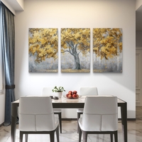 תמונת זכוכית שלישייה עם עץ זהוב ועלים מרחפים על רקע אפור בעיצוב מודרני