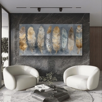 תמונת זכוכית לרוחב עם נוצות בגווני זהב ושמנת בעיצוב אלגנטי ומודרני לסלון