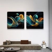 זוג תמונות זכוכית מרובעות בעיצוב אבסטרקטי עם קווים זורמים וכדורים בגווני טורקיז וזהב על רקע כהה.