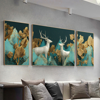 תמונת קנבס מחולקת בהדפסה חלקה של זוג איילים לבנים עם עלים מוזהבים על רקע טורקיז, בעיצוב יוקרתי לסלון.