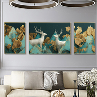 תמונת קנבס מחולקת בהדפסה חלקה של זוג איילים לבנים עם עלים מוזהבים על רקע טורקיז, בעיצוב יוקרתי לסלון.