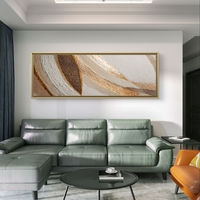 תמונת קנבס פנורמית אבסטרקטית בגווני בז’ וזהב מעל ספה אפורה בסלון מודרני.