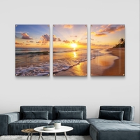 שלישיית תמונות זכוכית עם שקיעה זהובה על חוף הים, גלים עדינים וצבעים חמים בעיצוב רגוע ואלגנטי לסלון