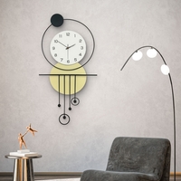 שעון קיר מעוצב בסגנון מודרני עם צורות גאומטריות, מסגרת עגולה, מטוטלות דקורטיביות וגימור אלגנטי בגווני שחור, לבן וזהב, תלוי על קיר בהיר.