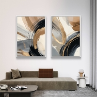 זוג תמונות קנבס מופשטות בגווני שחור, זהב וחום בהיר עם משיחות צבע רחבות בעיצוב מודרני