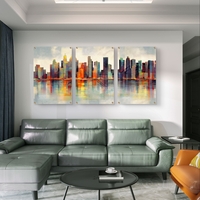 שלישיית תמונות זכוכית עם קו רקיע עירוני אבסטרקטי והשתקפות במים בגווני טורקיז וכתום