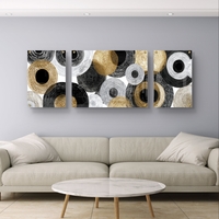 תמונת זכוכית מחולקת אבסטרקטית עם מעגלים בגווני שחור, לבן ואפור ונגיעות זהב