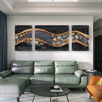 תמונת זכוכית מחולקת טריפטיכון בגווני שחור, אפור וזהב עם קווים זורמים ואבנים – תכשיט לבית