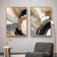 זוג תמונות קנבס מופשטות בגווני שחור, זהב וחום בהיר עם משיחות צבע רחבות בעיצוב מודרני