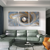 סט שלישייה של תמונות זכוכית אבסטרקטיות בגווני תכלת, לבן וזהב עם כדור מרכזי ועיצוב מודרני