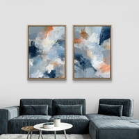 סט תמונות קנבס זוגי בגווני כחול, אפור וכתום בעיצוב אבסטרקטי רך – תכשיט לבית