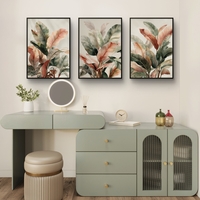 סט של שלוש תמונות קנבס עם איורי עלים בוטניים בגווני ירוק, שמנת וחום, בעיצוב עדין ומודרני לסלון.