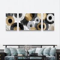 תמונת זכוכית מחולקת אבסטרקטית עם מעגלים בגווני שחור, לבן ואפור ונגיעות זהב