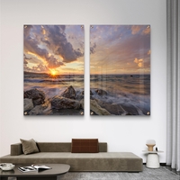 זוג תמונות זכוכית עם שקיעה מעל הים, סלעים וגלים בתנועה עדינה בעיצוב רגוע ואלגנטי לקיר הבית