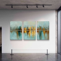 סט שלישייה של תמונות זכוכית אבסטרקטיות עם קו־רקיע עירוני בגווני תכלת וזהב והשתקפות מים