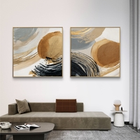 זוג תמונות קנבס מרובעות בסגנון מופשט עם מעגלים וקווים בגווני זהב, שחור ובז’ בעיצוב מודרני ויוקרתי