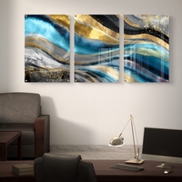 תמונת זכוכית מחולקת לשלושה חלקים בגווני טורקיז, שחור וזהב בעיצוב אבסטרקטי מודרני תלויה מעל שולחן אוכל לבן.