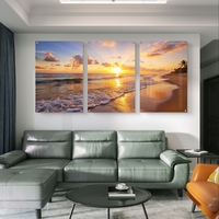 שלישיית תמונות זכוכית עם שקיעה זהובה על חוף הים, גלים עדינים וצבעים חמים בעיצוב רגוע ואלגנטי לסלון