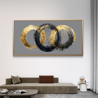 קנבס מודרני מעל ספה עם טבעות זהב נוצצות וטקסטורה שחורה, סגנון מינימליסטי יוקרתי