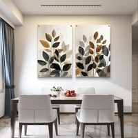 זוג תמונות זכוכית יוקרתיות עם הדפס עלים מינימליסטי בגוונים חמים וניטרליים.