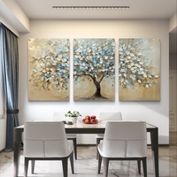 תמונת זכוכית מחולקת לשלושה חלקים עם עץ רחב עלים בגווני תכלת, בז' וזהב בעיצוב אומנותי תלת-ממדי