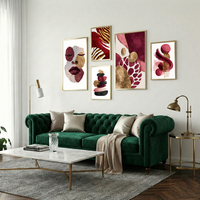 סט תמונות קנבס בגווני בורדו, ורוד וזהב עם פורטרט נשי ועיצוב אבסטרקטי מודרני תלוי מעל ספה בהירה בסלון מעוצב.