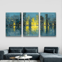 שלישיית תמונות זכוכית עם נוף עירוני אבסטרקטי ואורות זהב המשתקפים במים בעיצוב מודרני