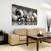 תמונת זכוכית לרוחב עם כדורי מתכת מבריקים ונוצות בגווני כסף ושמנת, בעיצוב יוקרתי ומודרני מתוך קולקציית תכשיט לבית.