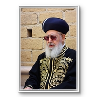 תמונת קנבס אנכית של רב יהודי בלבוש מסורתי שחור וזהב, תלויה מעל שולחן אוכל בעיצוב קלאסי.