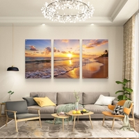 שלישיית תמונות זכוכית עם שקיעה זהובה על חוף הים, גלים עדינים וצבעים חמים בעיצוב רגוע ואלגנטי לסלון