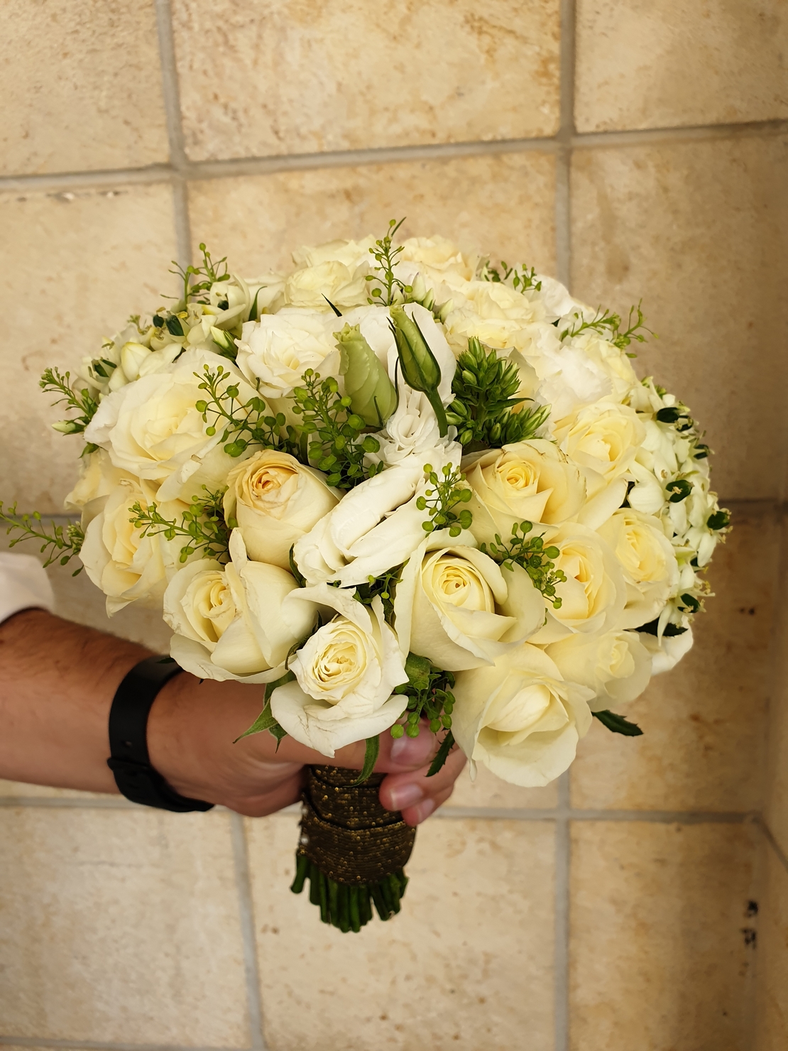 A white bridal bouquet with roses and lisianthus