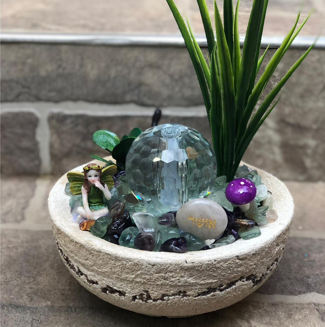 מזרקה עם פלורייט מוחלק בקערה עגולה עם כדור קריסטל 