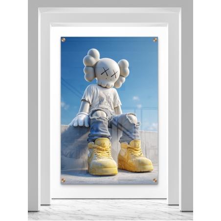 תמונת זכוכית של דמות KAWS בלבוש לבן וג’ינס יושבת על קיר בטון עם נעלי סניקרס צהובות על רקע שמיים כחולים – מתוך קולקציית NEXTGEN BY BAR של תכשיט לבית.