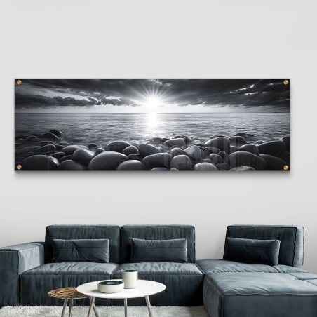 תמונת זכוכית פנורמית בשחור-לבן של שקיעה קסומה מעל חוף ים סלעי - עיצוב יוקרתי ואיכותי מבית 
